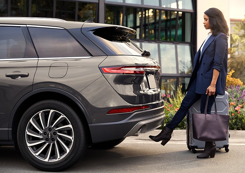 A woman with her hands full uses her foot to activate the available hands-free liftgate. | Vista Lincoln Woodland Hills in Woodland Hills CA